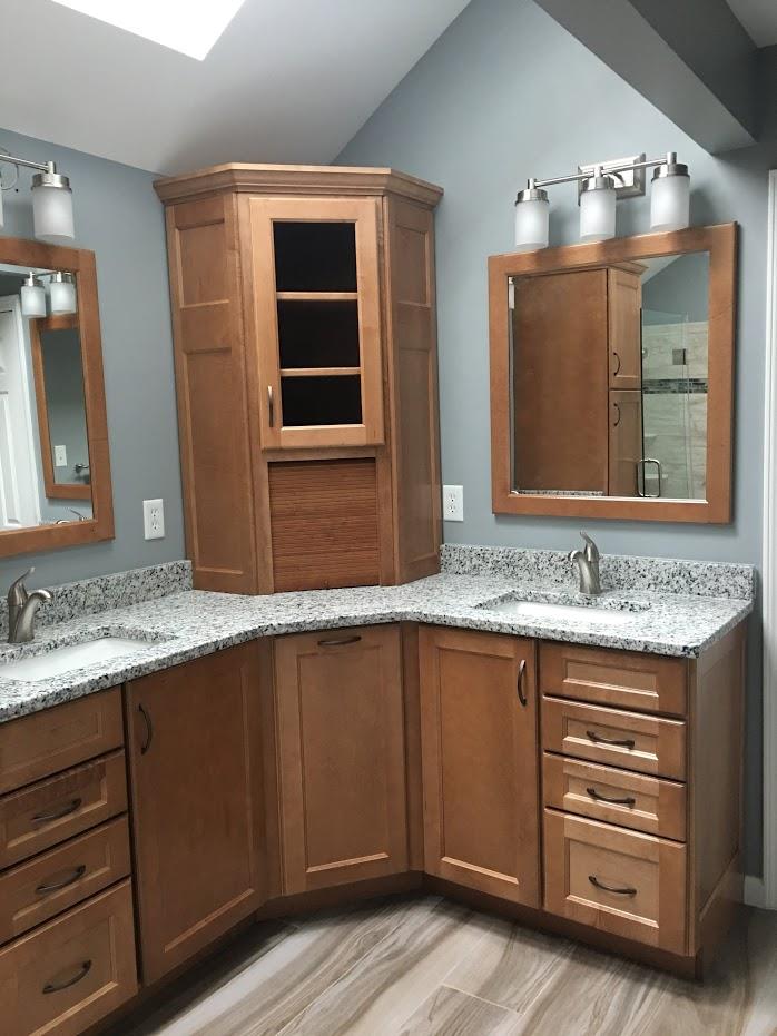corner powder room installation with wooden cabinets and drawers