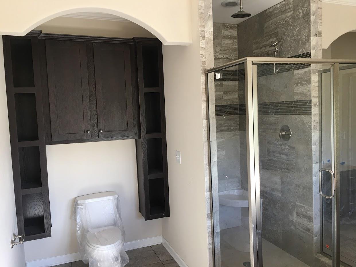 shower room with toilet and wooden cabinets