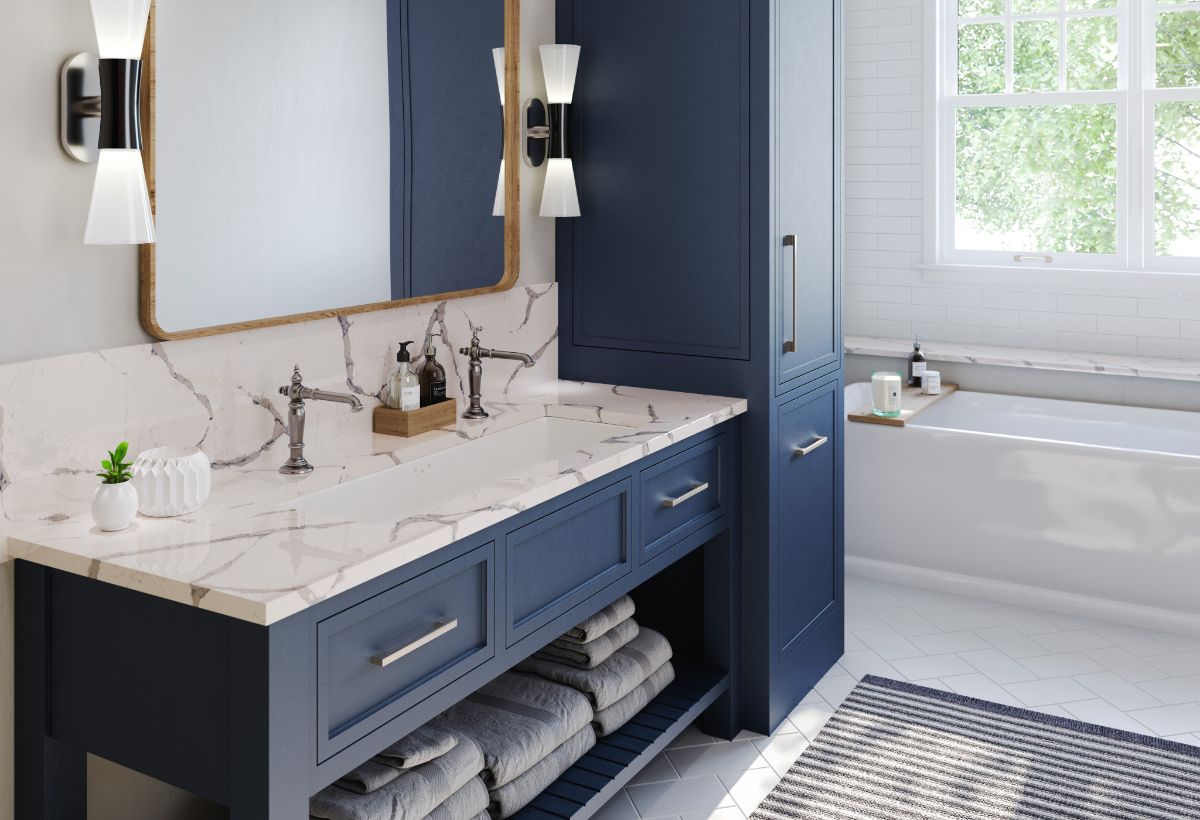 Cambria Countertop Stone with blue drawers, cabinets and wide mirror