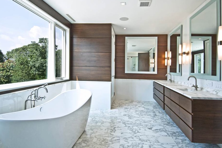 Craft-Maid Cabinets in a modern bathroom design with wall lamps and soak up bath tub