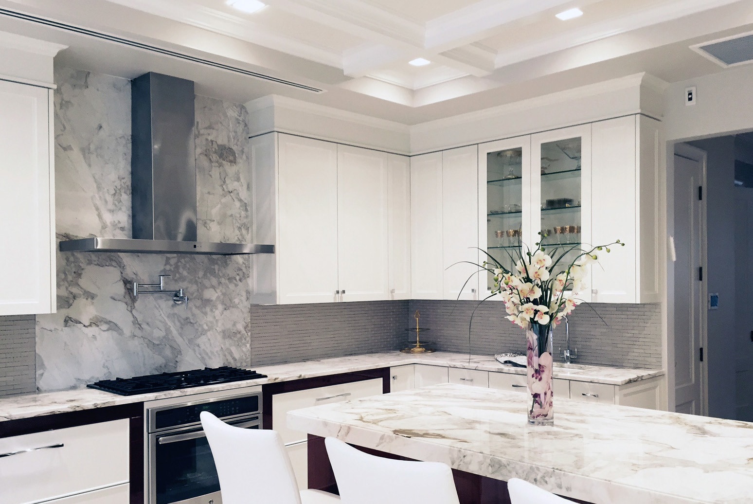 All white Craft-Maid Cabinets with stone counter top and classic lighting