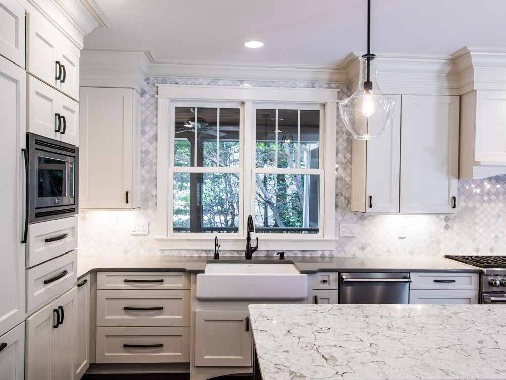 Marsh white kitchen cabinets with stone counter top and modern sink