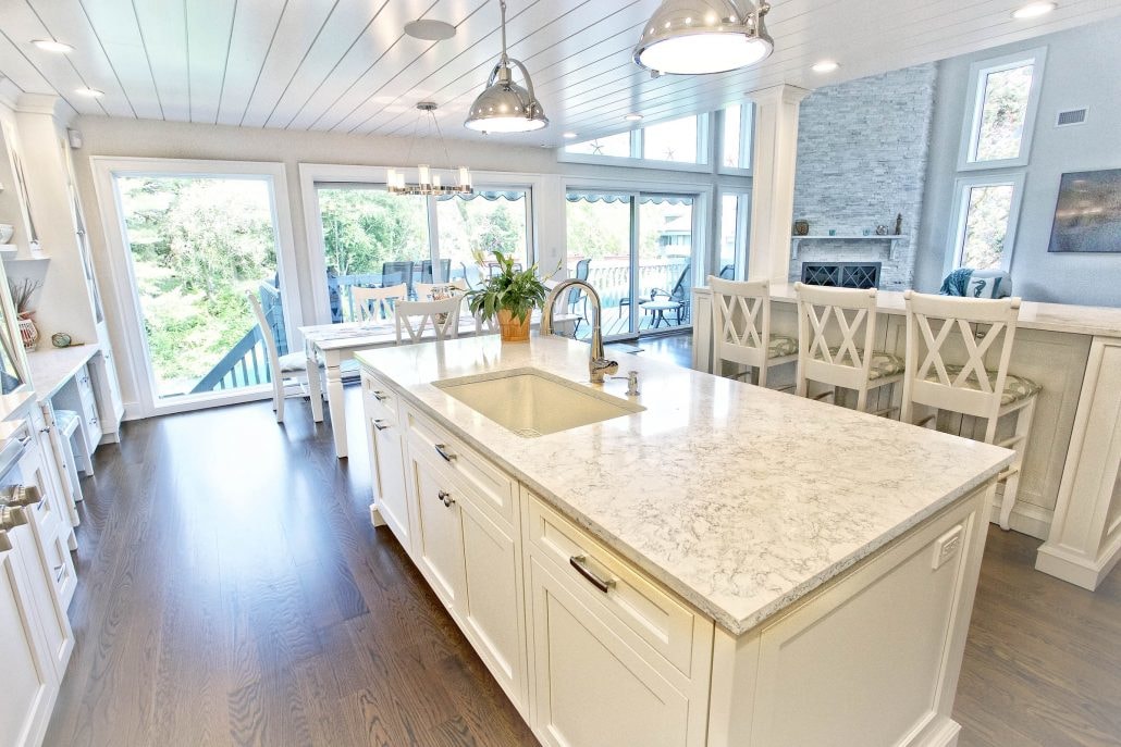 Spectrum Quartz Countertop Stone with cream cabinets, modern lighting and wooden stools