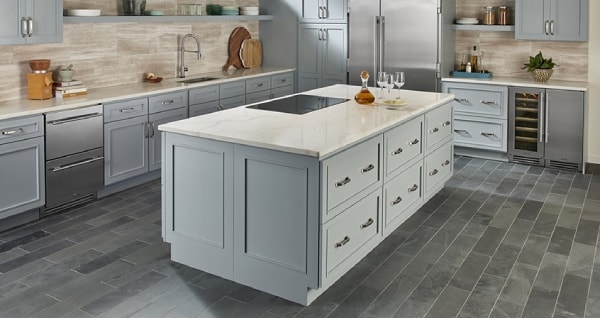 Stone kitchen counter top with hardwood flooring and grey cabinets